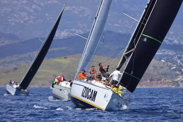 Bodrum, Hindi. 27 Nisan 2025: Ege Denizi 'nin mavi sularında, ünlü tatil beldesi Bodrum' un kıyılarında yelkenliler rüzgarlı havada yelken açıyor.