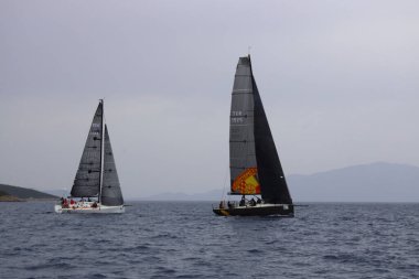 Bodrum, Hindi. 25 Mayıs 2025: Yelkenliler Ege Denizi 'nin mavi sularında, ünlü tatil beldesi Bodrum' un kıyılarında rüzgarlı havada yelken açıyorlar..