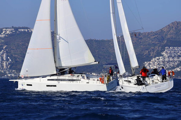 Бодрум, Турция. 01 февраля 2025: Парусники плывут в ветреную погоду в голубых водах Эгейского моря, на берегу знаменитого курорта Бодрум.