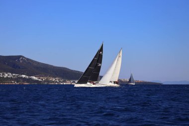 Bodrum, Hindi. 22 Şubat 2025: Yelkenliler Ege Denizi 'nin mavi sularında, ünlü tatil beldesi Bodrum' un kıyılarında rüzgarlı havada yelken açıyorlar..