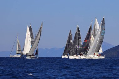 Bodrum, Hindi. 22 Şubat 2025: Yelkenliler Ege Denizi 'nin mavi sularında, ünlü tatil beldesi Bodrum' un kıyılarında rüzgarlı havada yelken açıyorlar..