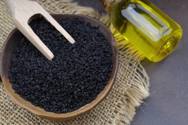 Siyah kimyon tohumları ve kase, tahta kürek ya da kaşık ile gerekli yağ. Nigella Sativa cam şişede. Birçok hastalık için organik bitkisel ilaç