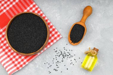 Siyah kimyon tohumları ve kase, tahta kürek ya da kaşık ile gerekli yağ. Nigella Sativa cam şişede. Birçok hastalık için organik bitkisel ilaç