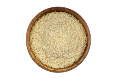 Beyaz arka planda, kırpma yolu ile izole edilmiş ahşap kasede taze toplanmış beyaz susam ağacının üst görüntüsü.