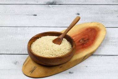 Tahta kasede yeni toplanmış beyaz susam ağacından yapılmış, ahşap arka planda izole edilmiş, kırpma yolu ile yakın plan görüntüsü..