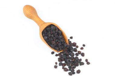 Beyaz arka planda izole edilmiş kepçedeki kuru üzümler