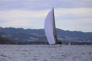 Bodrum, Hindi. 07 Nisan 2024: Ege Denizi 'nin mavi sularında, ünlü tatil beldesi Bodrum' un kıyılarında yelkenliler rüzgarlı havada yelken açıyor.