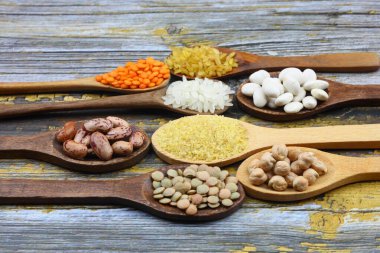 Farklı türde ham kuru baklagil kompozisyonu. Mercimek, kırmızı mercimek, nohut ve fasulye. Organik baklagil kavramını karıştır.