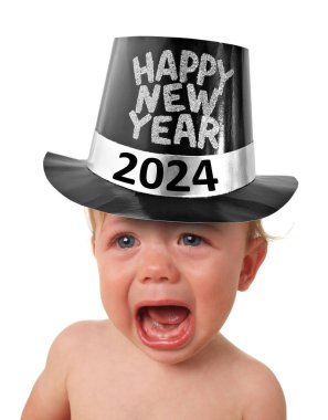 2024 Ağlayan ve üzgün bebek Mutlu Yıllar şapkası takıyor. Yeni yıl arifesinde mutsuz bir çocuk.. 
