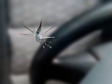 close up of a stone chip in the windshield of a car, detail shot of cracks in car glass on the drivers side. clipart