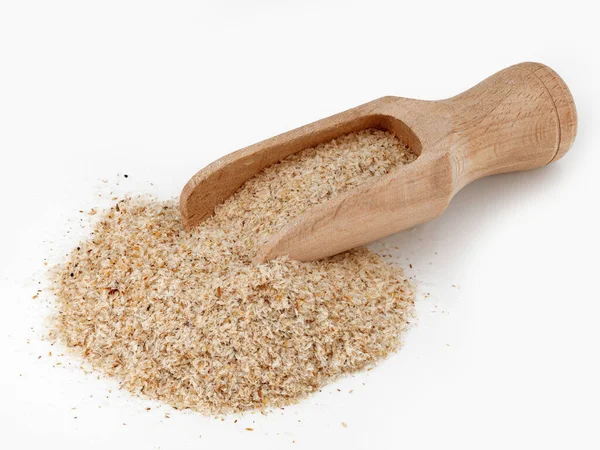 Beyaz arka planda izole edilmiş ahşap kepçedeki psyllium kabuğu yığını keto diyeti için iplik olarak kullanılan bitkisel Indica tohum kapsülleri..