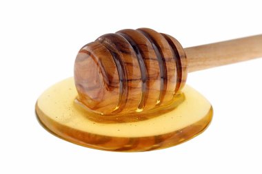 Yuvarlak bal damlası üzerine zeytin ağacı balı, beyaz arka planda bal damlası, bal kaşığı ve bir tutam bal..