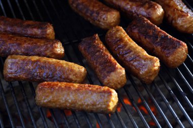 Kızarmış cevapi 'nin yakın çekimi, ızgarada ızgara kömürü, bbq' ın üzerinde geleneksel Balkan et sosisleri..