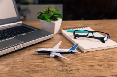 Ev masasını uçak modeli ve not defteri ile görüntüle