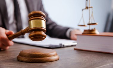 Bir adam kağıtları tutar ve sahaya vurur. Mahkemenin kararı.