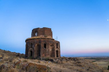 Güneş tepede harap olmuş eski bir tapınak.