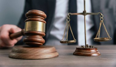 Bir adamın elinde yargıç tokmağı var. Hüküm terazisi. Mahkemenin kararı.