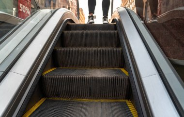 Alışveriş merkezindeki merdiven boşluğunda. Adam ayakta duruyor.