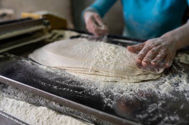Woman processing the dough with flou