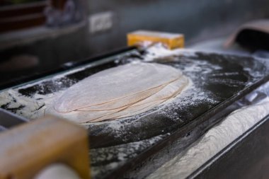 Thin dough and flour on the tabl