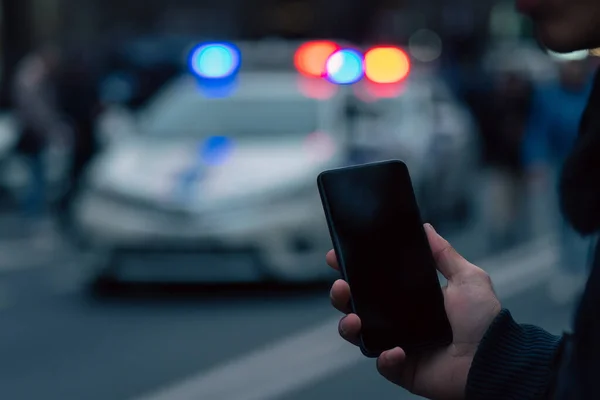 Memegang Telepon Terhadap Latar Belakang Mobil Polisi Cit — Stok Foto