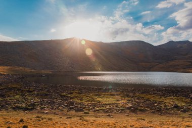 Lake and sunset behind the mountai