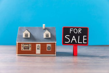 Masada satılık tabelası olan küçük bir ev.