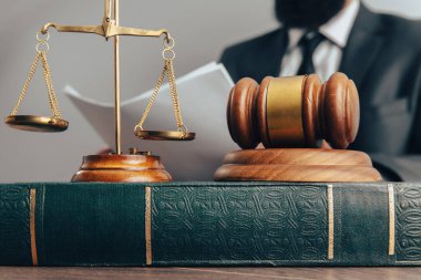 The judge examines the papers while sitting in front of the hammer and scales. scales of justic