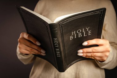 Bir kadın elinde İncil 'i tutuyor. İnan.