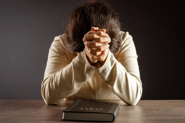 Woman praying on the bible. Believe