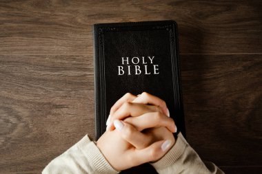 İncil 'in üzerinde dua eden kadın. İnan.