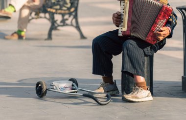 Sokak müzisyeni akordeon çalar ve para ister