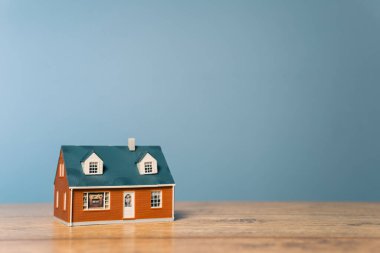 Ahşap bir masanın üzerindeki ahşap ev modeli.