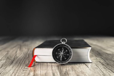 Kitap ve pusula masanın üstünde. Dünyanın konsept yönü