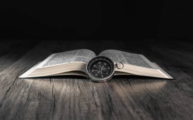 Kitap ve pusula masanın üstünde. Dünyanın konsept yönü