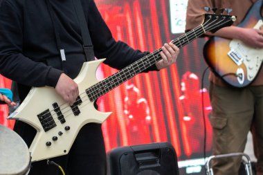 Bir adam sokakta elektro gitar çalıyor.