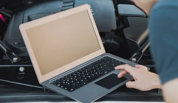 The technician does car diagnostics using a laptop. car inspectio
