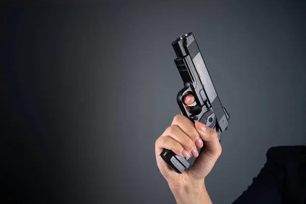 Woman holding a gun in a dark roo