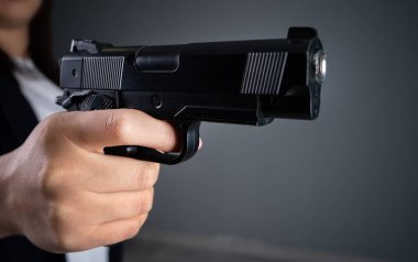 Karanlık bir kanguruda silah tutan bir kadın.