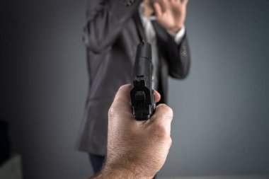 Silahı kancadaki kişiye doğrulttu.