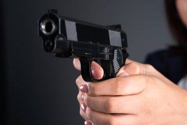 Karanlık bir kanguruda silah tutan bir kadın.