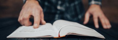 Genç adam karanlık sırtı hakkında kitap okuyor.