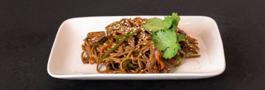 Popüler Malezyalılar beyaz tabakta kızarmış erişte pişiriyor.