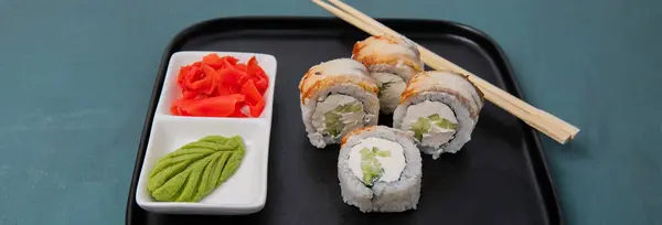Sushi rolls on a tray. Sushi tray on a dark background