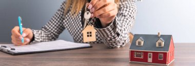 Kadın elinde ev anahtarı ve belgeyi masaya koyuyor