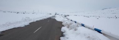 Karanlıkta karlı manzaralı asfalt yol.