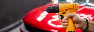 Girdi üzerinde çalışırken araba tamir matkabı bekletiliyor