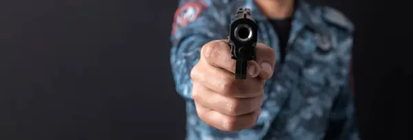 Military man holding a gun in han