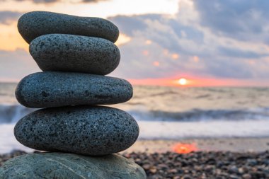 Gün batımında kumsalda bir çakıl taşında denge