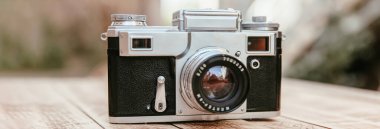 Ahşap bir masanın üzerinde klasik bir kamera.